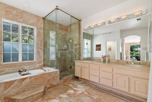 bathroom with marble finish floor, a sink, a shower stall, a garden tub, and double vanity