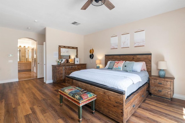 bedroom featuring arched walkways, baseboards, visible vents, and wood finished floors