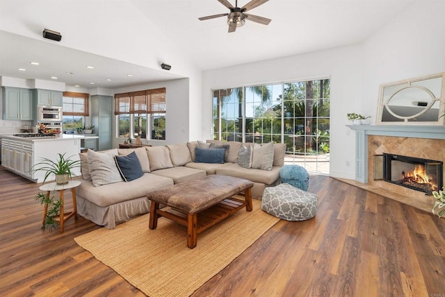 living area featuring high vaulted ceiling, recessed lighting, a fireplace, dark wood-style flooring, and ceiling fan