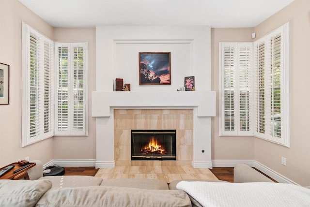 bedroom featuring wood finished floors, baseboards, and a tile fireplace