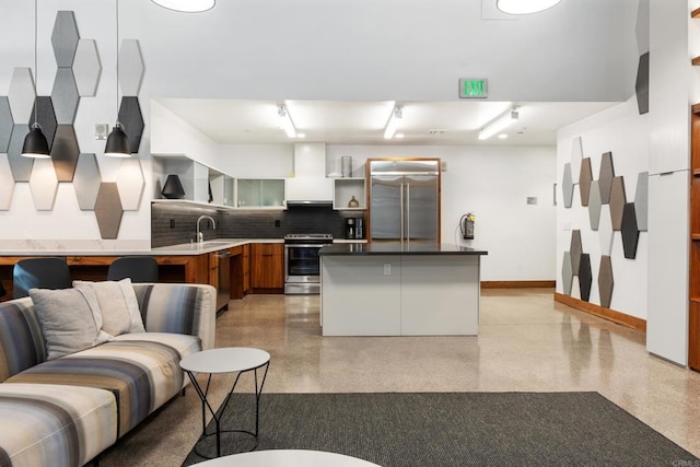350 11th Ave Unit 928, San Diego, CA 92101 - kitchen with stainless steel appliances, decorative backsplash, a sink, and light speckled floor