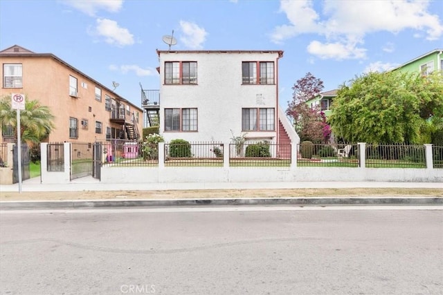 1919 W 35th St, Los Angeles, CA 90018 - view of front of property featuring stairs, a fenced front yard, and stucco siding