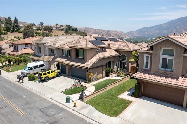 5530 Van Gogh Way, Yorba Linda, CA 92887 - view of front of home featuring an attached garage, driveway, stucco siding, a mountain view, and solar panels