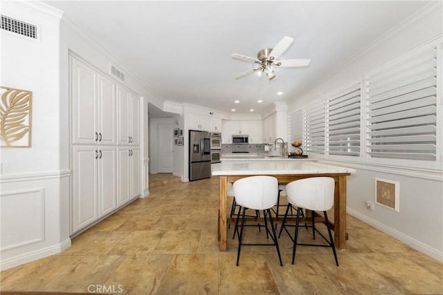 5530 Van Gogh Way, Yorba Linda, CA 92887 - kitchen featuring appliances with stainless steel finishes, a breakfast bar, white cabinetry, light countertops, and a ceiling fan