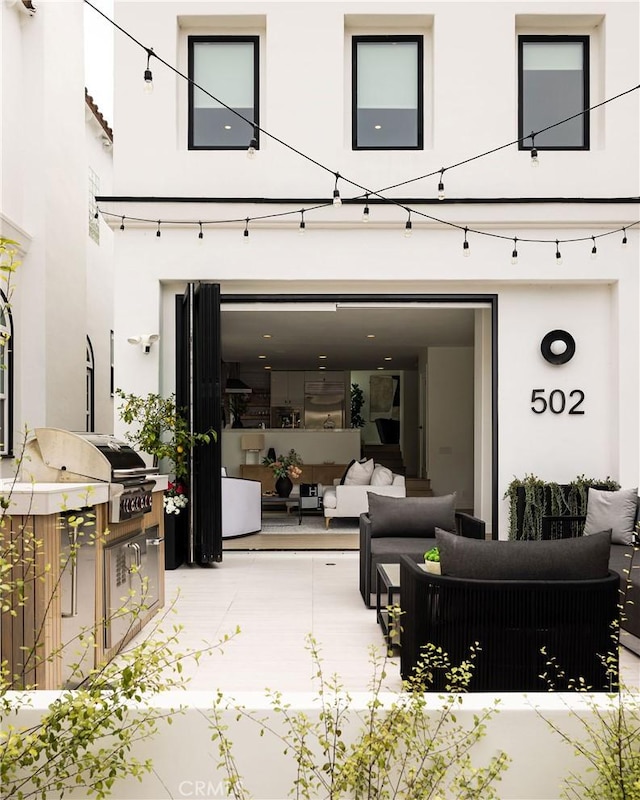 back of house with outdoor lounge area and stucco siding