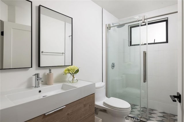 bathroom with vanity, toilet, and a stall shower