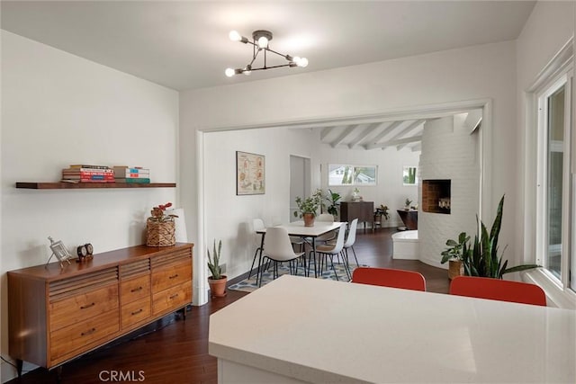 dining room with beamed ceiling, dark wood finished floors, and an inviting chandelier