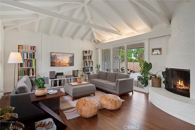 living room with a fireplace, lofted ceiling with beams, and hardwood / wood-style floors