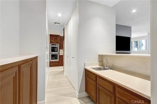 bathroom with baseboards, recessed lighting, visible vents, and a sink