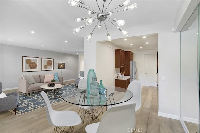 dining room with recessed lighting, baseboards, a notable chandelier, and light wood-style floors