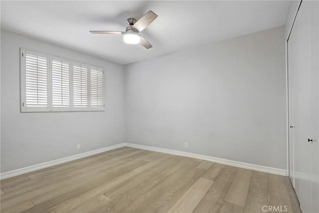 empty room with a ceiling fan, baseboards, and light wood finished floors