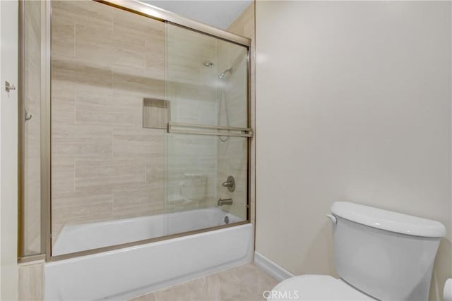 full bath with toilet, baseboards, and shower / bath combination with glass door