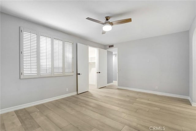 unfurnished bedroom featuring light wood-type flooring, baseboards, visible vents, and a ceiling fan
