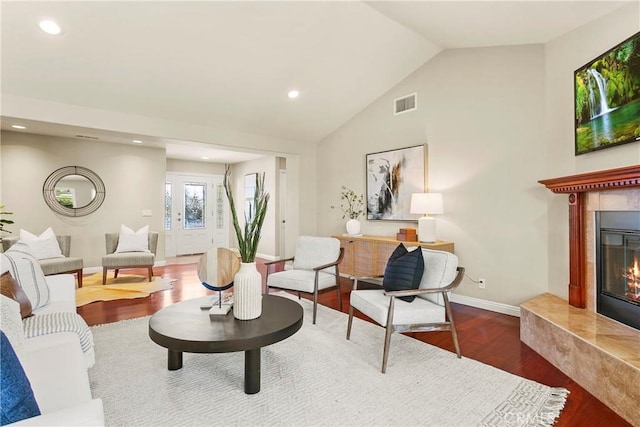 living room with recessed lighting, a tiled fireplace, visible vents, and wood finished floors