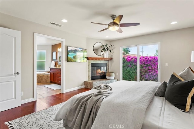 bedroom with recessed lighting, a tiled fireplace, visible vents, and dark wood-type flooring