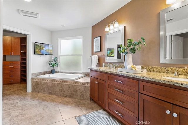 bathroom featuring a sink, double vanity, a garden tub, and visible vents