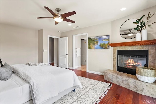 bedroom with wood finished floors, visible vents, recessed lighting, baseboards, and a tile fireplace