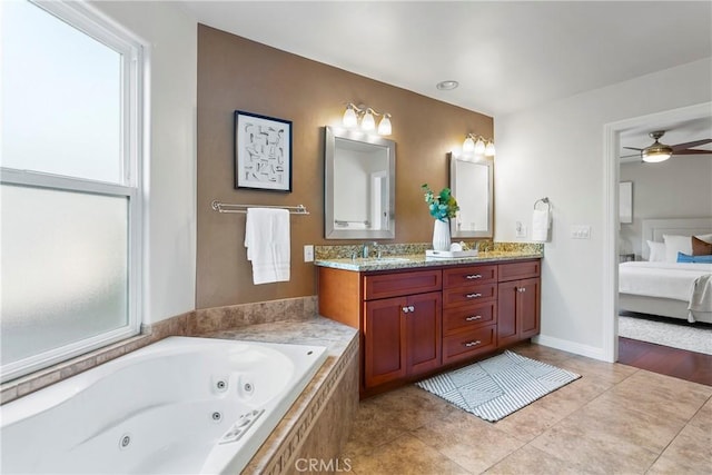 ensuite bathroom with double vanity, a jetted tub, a sink, ensuite bathroom, and tile patterned flooring