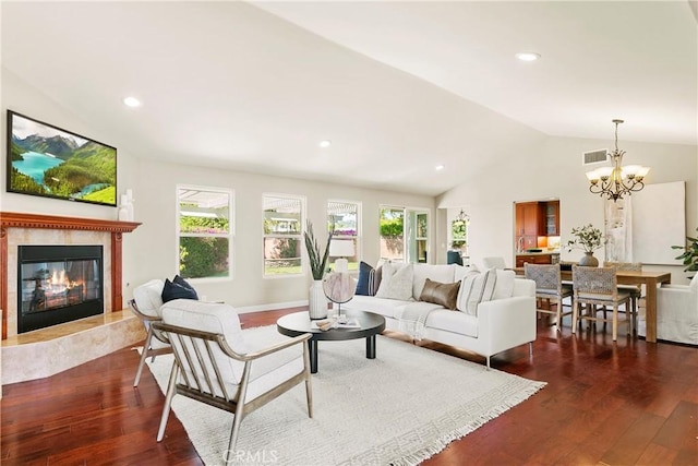 living room with lofted ceiling, a wealth of natural light, visible vents, and wood finished floors