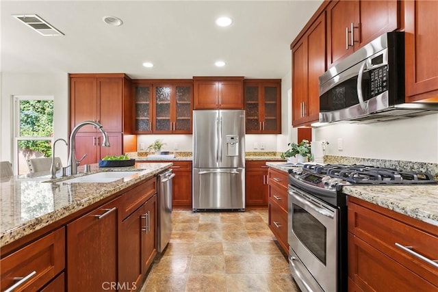 kitchen with glass insert cabinets, a sink, visible vents, appliances with stainless steel finishes, and recessed lighting