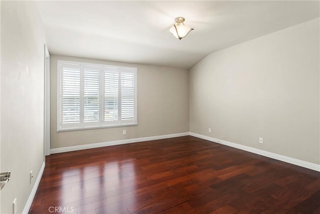 spare room featuring baseboards and wood finished floors
