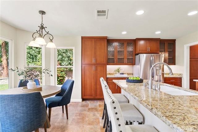 kitchen with a breakfast bar area, recessed lighting, visible vents, a sink, and stainless steel fridge with ice dispenser
