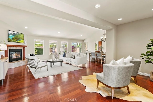 living area featuring wood finished floors, a high end fireplace, a chandelier, lofted ceiling, and recessed lighting