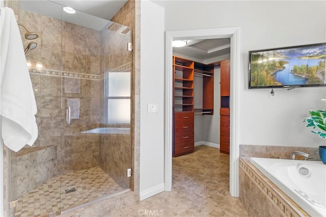 full bath featuring a spacious closet, a shower stall, a bath, and tile patterned floors