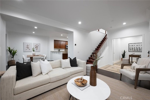 living room with stairs, ornamental molding, light wood finished floors, and recessed lighting