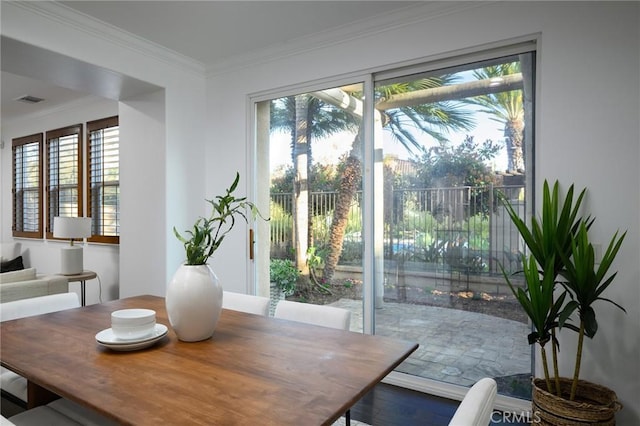 dining area with ornamental molding, visible vents, and plenty of natural light