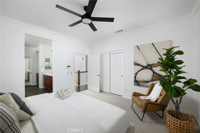 bedroom featuring crown molding, ensuite bath, visible vents, and a closet