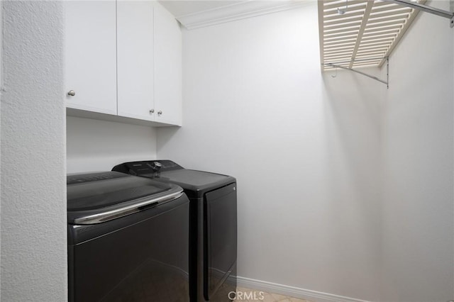 clothes washing area with washing machine and clothes dryer, ornamental molding, and cabinet space