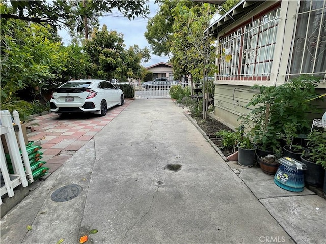 exterior space with a gate, fence, and driveway
