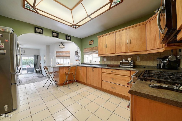 2030 Lomita Park Pl, Lomita, CA 90717 - kitchen with a peninsula, arched walkways, dark countertops, and appliances with stainless steel finishes