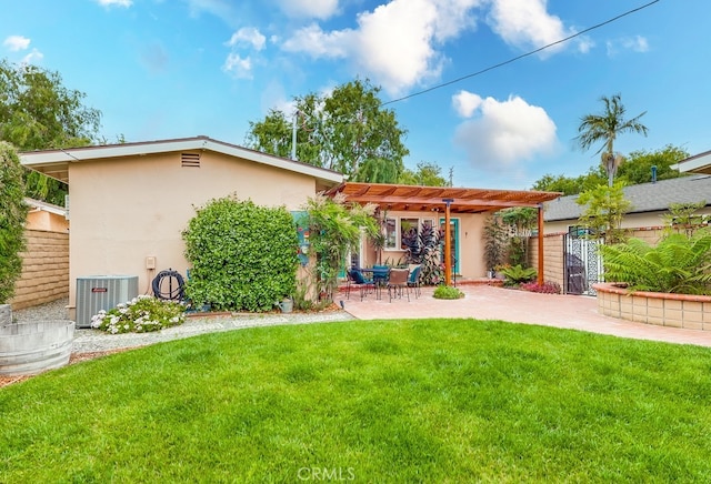 back of house with a patio, stucco siding, a pergola, a lawn, and central AC unit