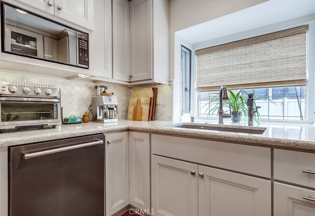 kitchen featuring white cabinets, stainless steel appliances, and backsplash