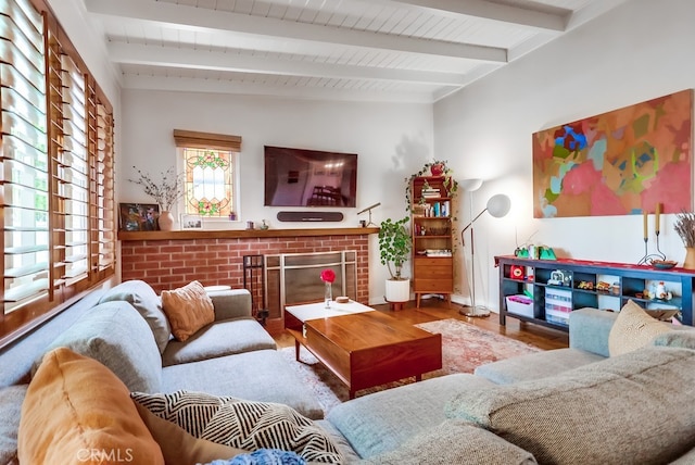 living room featuring a fireplace, vaulted ceiling with beams, and wood finished floors