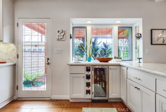 doorway featuring light wood-style floors, plenty of natural light, and wine cooler