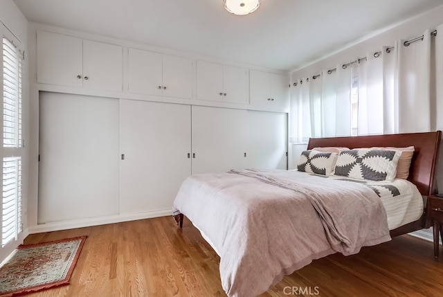 bedroom featuring light wood-style flooring and multiple windows