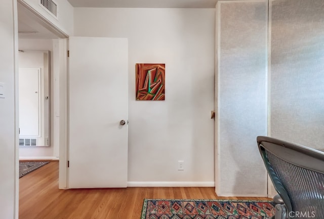office featuring baseboards, light wood-style floors, and visible vents