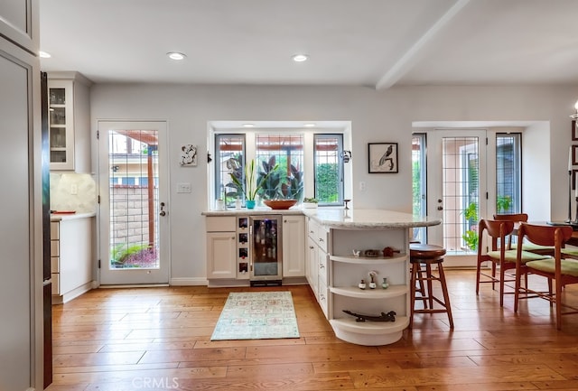 bar with wine cooler, light wood-style floors, recessed lighting, and plenty of natural light