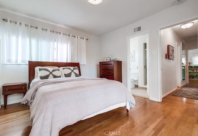 bedroom featuring visible vents, light wood-style flooring, and baseboards