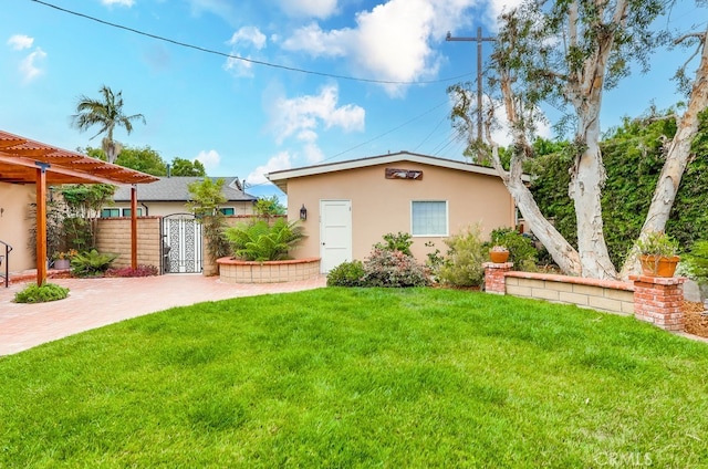 view of front of home with a gate, fence, a patio area, stucco siding, and a front yard