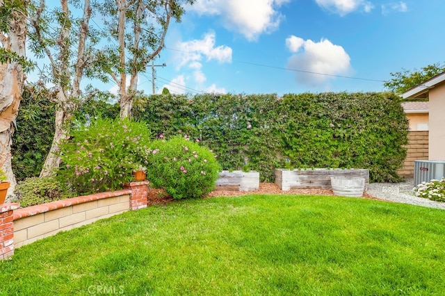 view of yard with central air condition unit, a vegetable garden, and fence