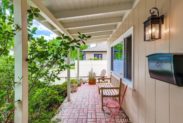 view of patio / terrace with a porch and fence