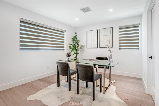 office with baseboards, light wood-style floors, a healthy amount of sunlight, and visible vents