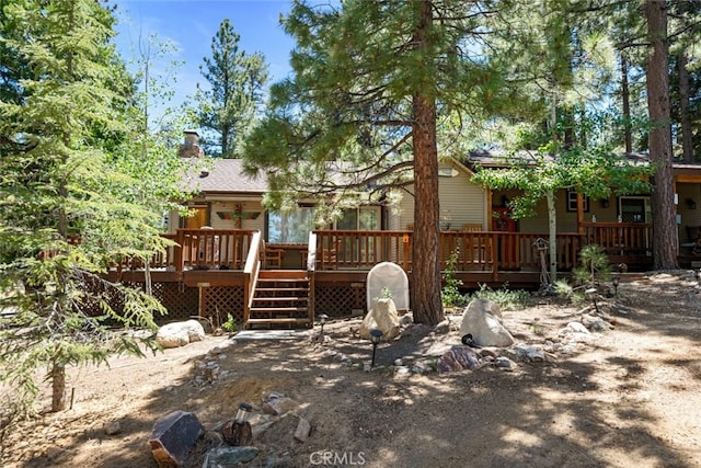 back of property with a deck and a chimney