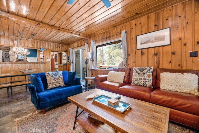 living room featuring wood walls, beam ceiling, wood ceiling, and ceiling fan with notable chandelier