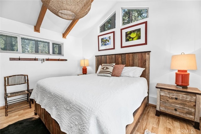 bedroom with baseboards, wood finished floors, and lofted ceiling with beams
