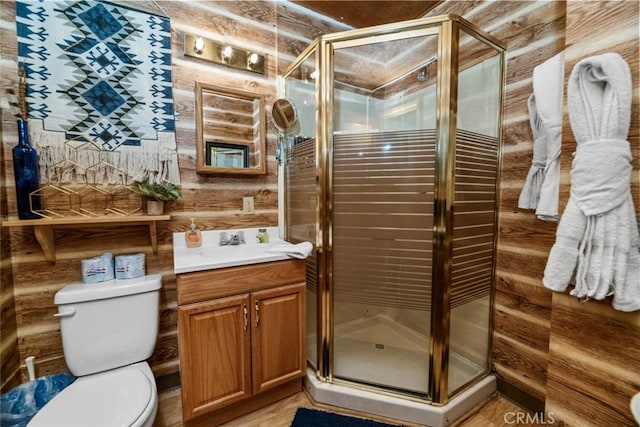 bathroom featuring toilet, vanity, and a stall shower